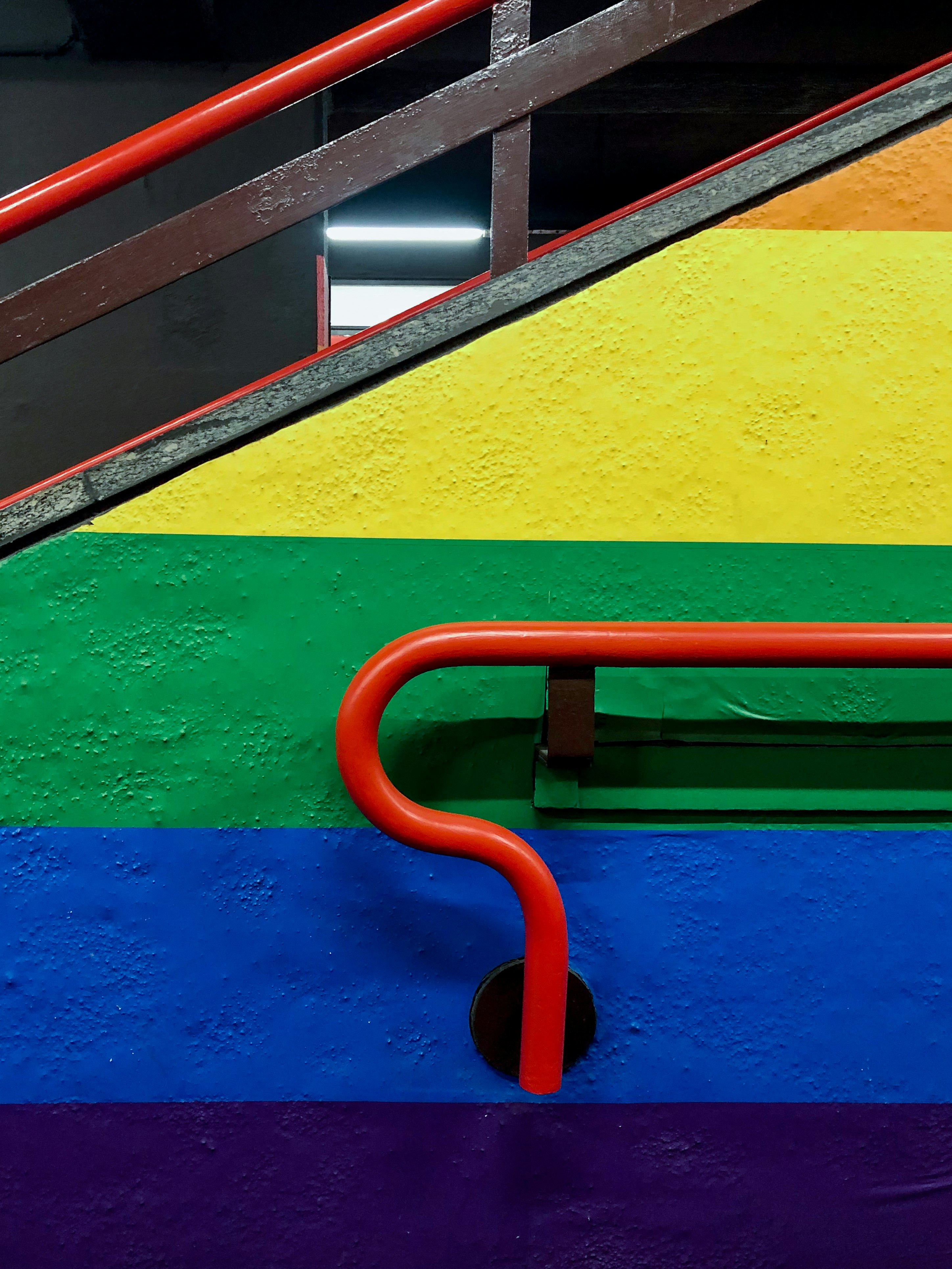 red metal railings on yellow and green concrete wall